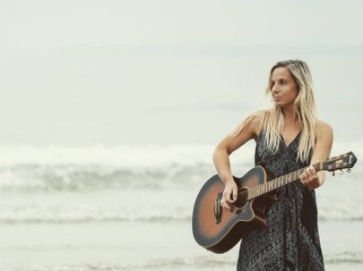 Laura Kate Music playing guitar on the beach