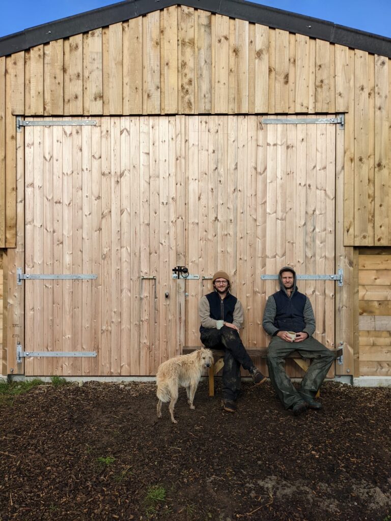 Rory and Milo sat together on a bench in front of a barn