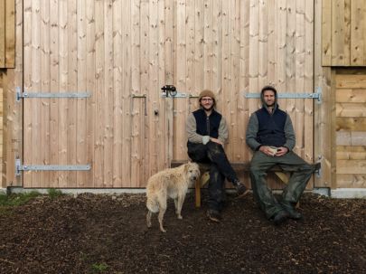 Earthbound team sitting outside a shed with a dog