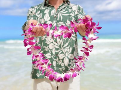 man in a hawaiian shirt with a flower necklace